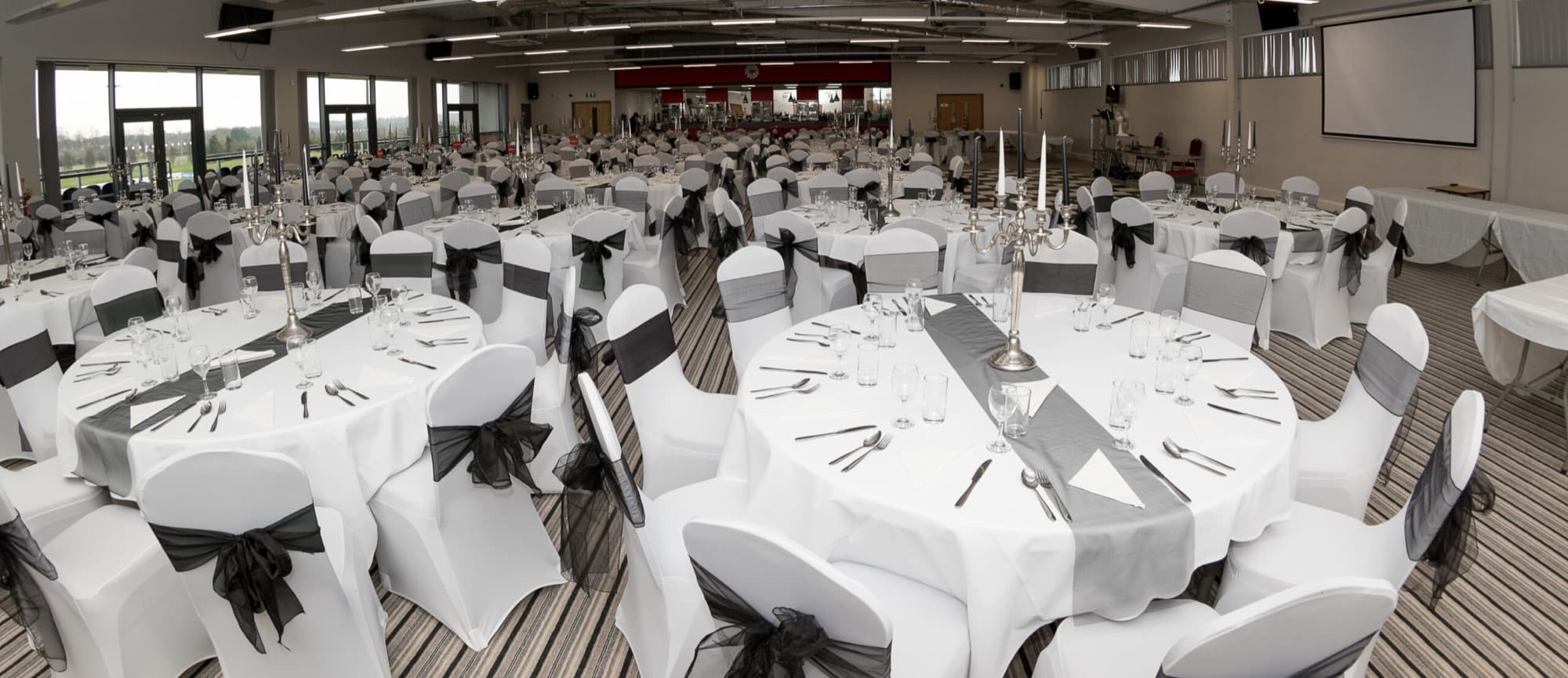 The Reddings Suite laid out with white linen for a banquet, with pitch views
