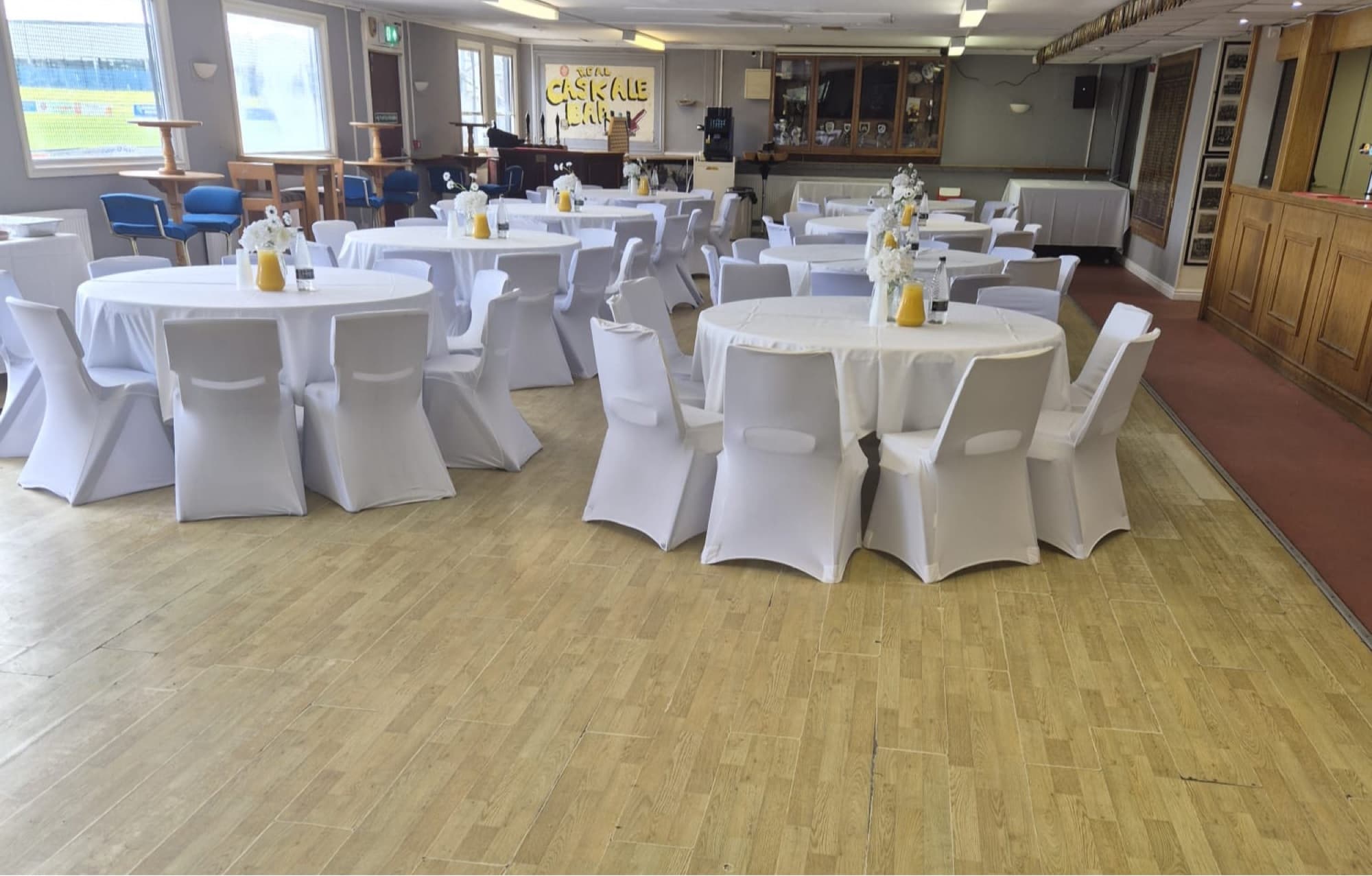 The Clubhouse set with round tables and a wooden dance floor