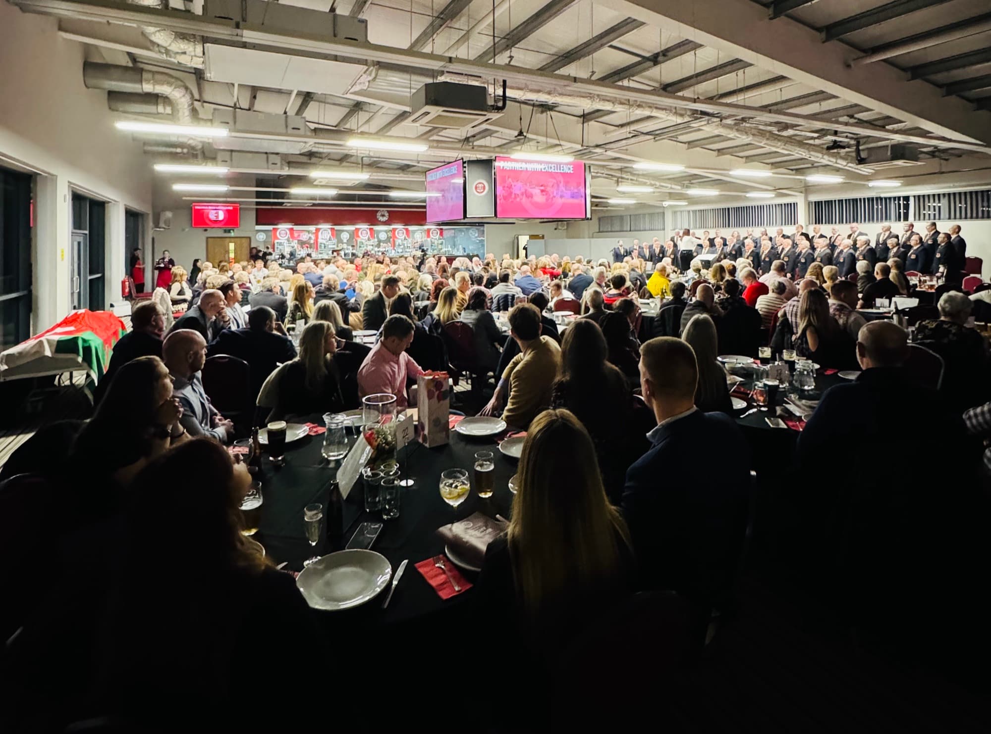 A packed evening dinner in The Reddings Suite with a stage and screens