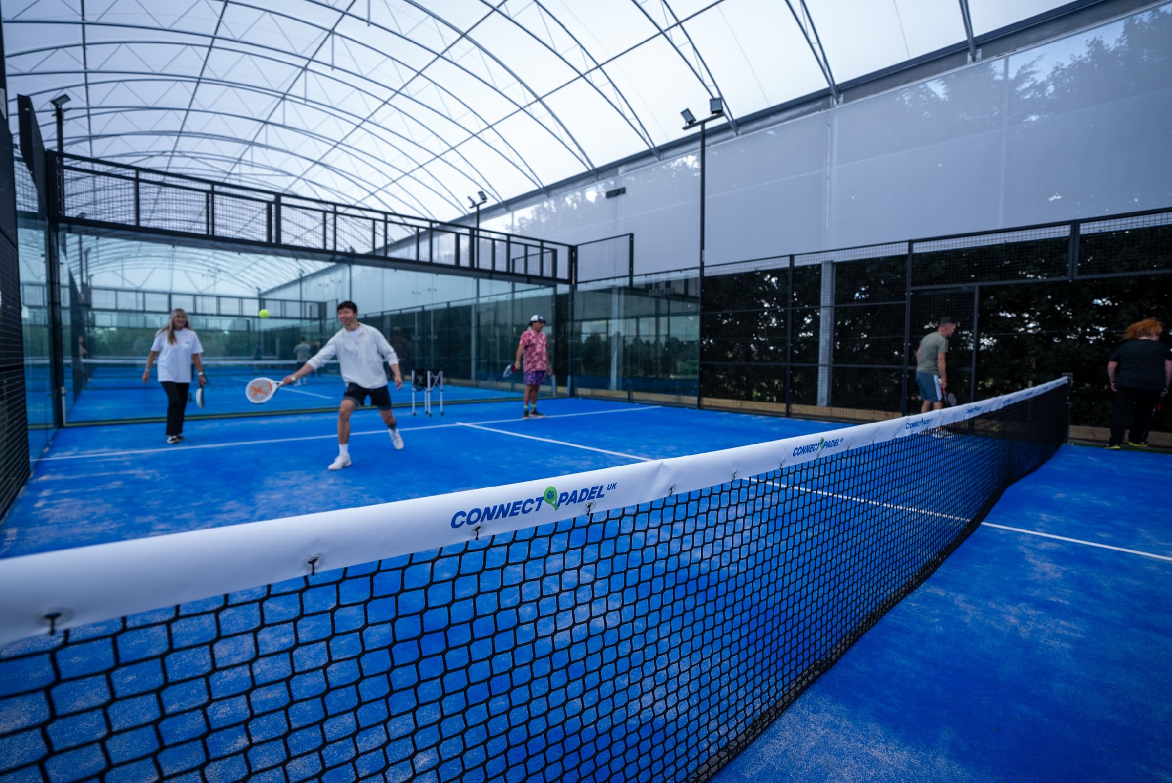 Players in a padel match on the courts at the sporting village