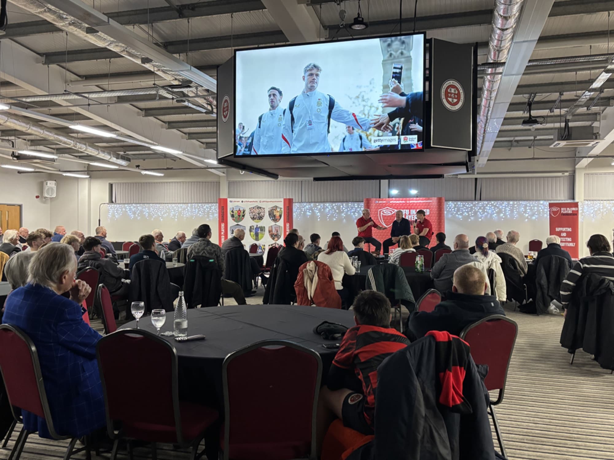 A business audience watching a presentation on the big screen at Birmingham Sporting Village